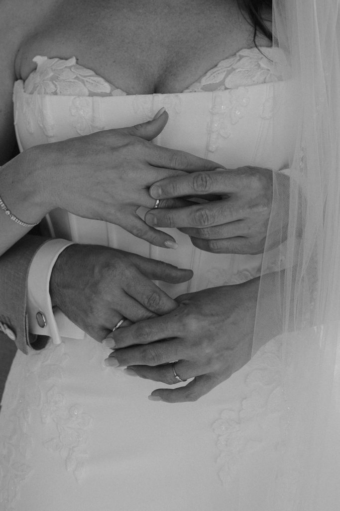 Veir Hände bvor dem Körper der Braut.